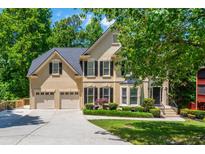 Beautiful two-story home boasts manicured landscaping, a two-car garage, and mature trees at 12350 Stevens Creek Dr, Alpharetta, GA 30005