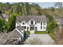 Stunning two-story home with a white exterior, complemented by lush landscaping and a gray tile roof at 3888 Peachtree Dunwoody Rd, Atlanta, GA 30342