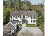 Stunning home featuring a light grey driveway, manicured lawn and eye-catching black-trim windows at 3888 Peachtree Dunwoody Rd, Atlanta, GA 30342