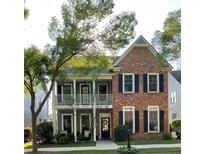 Charming two-story home with brick and siding, complemented by a cozy balcony and manicured lawn at 655 Grove Manor Ct, Suwanee, GA 30024