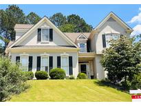 Charming home featuring a well-manicured lawn, lush landscaping, and traditional architectural details at 1739 Praters Pt, Dacula, GA 30019