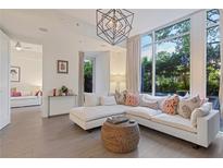 Bright living room featuring a large window, modern light fixture, and comfortable white sectional couch at 1820 Peachtree St # 311, Atlanta, GA 30309