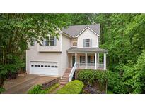 Charming two-story home with a well-manicured lawn, an attached garage, and a welcoming front porch at 3370 Ashton Dr, Suwanee, GA 30024