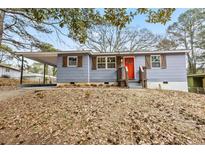 Charming single-story home featuring a bright orange front door, shutters, and a covered carport at 2608 Barge Sw Rd, Atlanta, GA 30331