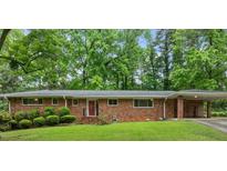 Charming single-story brick home with a well-maintained front yard and a covered carport at 1728 N Holly Ne Ln, Atlanta, GA 30329