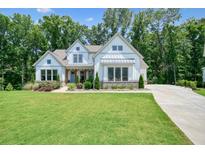 Beautifully landscaped front yard with lush green lawn and charming two-story white home at 2861 Digna Ct, Acworth, GA 30101