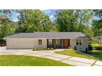 Charming single story home with modern curb appeal, featuring a brick facade and well-manicured lawn at 1377 Oak Grove Dr, Decatur, GA 30033