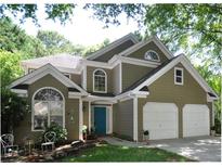 Charming two-story home featuring a two-car garage, manicured lawn and a welcoming teal front door at 2735 Royal Blf, Decatur, GA 30030
