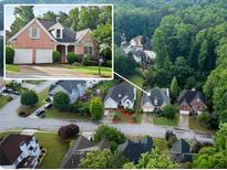 Aerial view of a brick home surrounded by lush greenery in a residential neighborhood at 3082 Monarch Pine Dr, Peachtree Corners, GA 30071