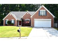 Charming brick home with well-manicured lawn, two-car garage, and inviting front entrance at 1162 Apalachee Run Trl, Dacula, GA 30019