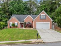 Charming one-story brick home with attached garage and well-manicured lawn at 1162 Apalachee Run Trl, Dacula, GA 30019