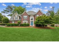 Charming two-story brick home with a well-manicured lawn and a bright blue front door at 840 Yosemite Dr, Suwanee, GA 30024
