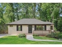 Charming one-story home with a light painted brick exterior, a cozy front porch, and a well-maintained landscaped yard at 2156 Doris Dr, Decatur, GA 30034