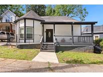 Charming renovated home with covered porch, black and white trim and unique turret style architecture at 509 Roy Sw St, Atlanta, GA 30310