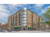 Tan brick condo building featuring a corner glass facade, private balconies, and street-level retail at 201 W Ponce De Leon Ave # 515, Decatur, GA 30030