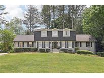 Charming two-story house with gray siding, dormer windows, black shutters, mature trees, and a lush front lawn at 3501 Emperor Way, Tucker, GA 30084