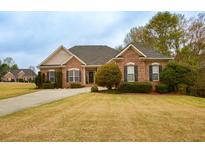 Charming brick home featuring manicured front lawn and complemented by mature trees at 118 Jasmine Way, Carrollton, GA 30180