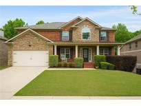 Charming two-story home with brick and stone accents, manicured lawn, and a welcoming front porch at 4415 Saint Andrews Crest Dr, Cumming, GA 30040