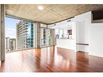 Bright living room with hardwood floors, city views from floor-to-ceiling windows, and an open layout at 855 Peachtree Ne St # 2001, Atlanta, GA 30308