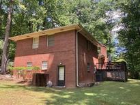 A well-maintained backyard featuring a full brick house and a wooden deck, perfect for outdoor entertaining at 9278 Seminole Rd, Jonesboro, GA 30236
