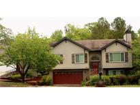 Charming two-story home featuring a red garage door, complemented by lush landscaping at 1425 Watercrest Cir, Lawrenceville, GA 30043