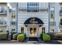 Elegant condo building entrance with black awning and landscaped shrubbery at 3203 Lenox Ne Rd # 22, Atlanta, GA 30324