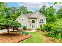 Charming two-story home boasts lush landscaping, a welcoming front porch, and a classic architectural design at 10490 Cranchester Way, Alpharetta, GA 30022