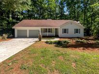 Charming single-story home with a manicured lawn and a three-car attached garage at 3766 Windy Hill Se Dr, Conyers, GA 30013