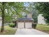 Charming two-story home with a two-car garage and well-maintained landscaping at 6664 Saint Jude Dr, Fairburn, GA 30213
