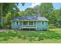 Charming, light green single-story home with a cozy front porch and well-manicured lawn at 100 Davis Mill N Rd, Dallas, GA 30157