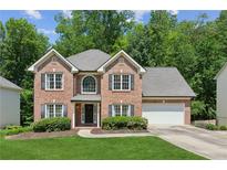 Charming two-story brick home featuring a well-manicured lawn and a two-car garage at 610 Golden Meadows Ln, Suwanee, GA 30024