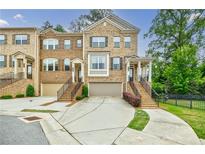 Charming brick townhome with a two-car garage, beautiful landscaping, and inviting front porch at 2464 Georgetown Ave, Atlanta, GA 30345