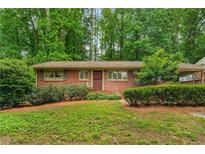 Charming one-story brick home with mature landscaping, a welcoming front door, and ample natural light at 2556 Defoors Ferry Nw Rd, Atlanta, GA 30318