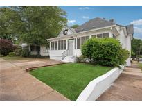 Charming home with a well-manicured lawn and a screened-in front porch, perfect for relaxing outdoors at 1796 Center Ave, East Point, GA 30344