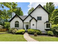 Charming home featuring a blend of brick and siding, a beautifully landscaped yard, and a welcoming walkway at 5600 Surrey Ct, Alpharetta, GA 30009