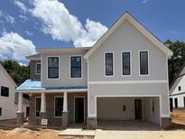 Two-story home featuring light gray siding, a two-car garage, brick accents, and black trimmed windows at 5627 Meadowstone Walk, Kennesaw, GA 30152