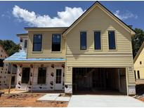 Two-story home with yellow siding and an attached two-car garage at 5627 Meadowstone Walk, Kennesaw, GA 30152
