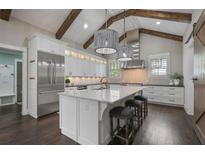 Modern kitchen featuring stainless steel appliances, a large island, and elegant lighting fixtures and wooden beams at 2908 Mabry Ne Ln, Brookhaven, GA 30319