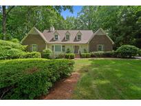 Charming brick home with manicured lawn and mature trees providing shade and curb appeal at 50 Stonington Pl, Marietta, GA 30068
