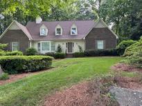Charming brick home with manicured lawn and mature trees providing shade and curb appeal at 50 Stonington Pl, Marietta, GA 30068