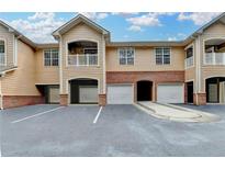 Tan condo building with garages on the lower level and a second-story balcony at 3500 Sweetwater Rd # 522, Duluth, GA 30096