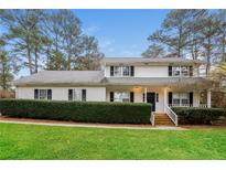 Charming home with a well-maintained lawn, mature trees, and welcoming front porch at 592 Cricket Hill Trl, Lawrenceville, GA 30044