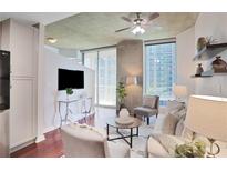 Bright living room with hardwood floors, modern furniture, and large windows with city views at 855 Peachtree Ne St # 1311, Atlanta, GA 30308