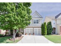 Charming home with a two-car garage, stone accents, manicured lawn, and mature landscaping at 5730 Weddington Dr, Cumming, GA 30040