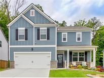 Charming two-story home with blue siding, black shutters, and a welcoming front porch at 7730 Demeter Dr, Fairburn, GA 30213