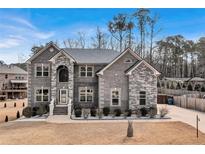 Stunning two-story home with a stone and brick facade, lush landscaping, and a welcoming front porch at 2994 Ash Grove Sw Dr, Conyers, GA 30094