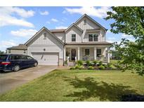 Charming two-story home with a well-manicured lawn and a welcoming front porch at 7095 Evening Dew Dr, Cumming, GA 30028