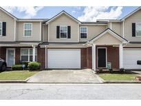 Charming townhome featuring brick accents, a single-car garage, and a welcoming front entrance at 132 Tara Commons Dr, Loganville, GA 30052