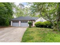Charming home featuring an attached two-car garage and a lush, green front yard at 410 Lima Ct, Woodstock, GA 30188