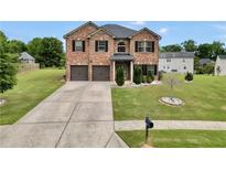 Charming two-story brick home with a well-manicured lawn and a two-car garage at 85 Foxgrove Cv, Covington, GA 30014